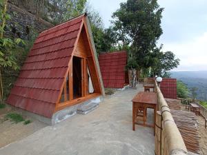 金塔马尼The Panorama Batur Camp的一间设有红色屋顶和桌子的小房子