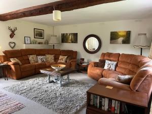威尔汉姆Cottages at Woodlands, Dormer的客厅配有2张棕色沙发和1张桌子