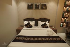 德瓦尔卡Pride Comfort Dwarka的一间卧室配有一张带黑白枕头的床