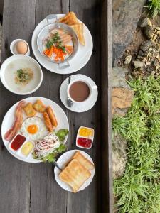 Ban Thung SangBaanrimfai Homestay的餐桌,早餐盘和咖啡盘
