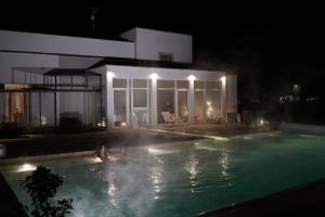 Caprarica di LecceMasseria Rifisa AgriResort的夜间在游泳池游泳的人