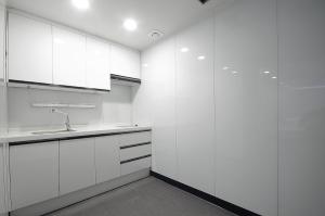 釜山WA酒店的白色的厨房配有白色橱柜和水槽
