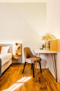 布拉索夫CASA CHITIC - HOTEL & RESTAURANT- Str Nicolae Balcescu 13的卧室配有1张床、1张桌子和1把椅子