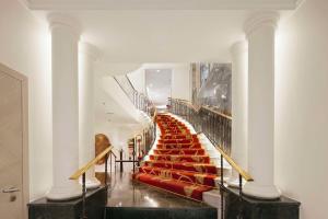 马德里马德里普拉多大道NH精品酒店的大楼里红色座椅的楼梯