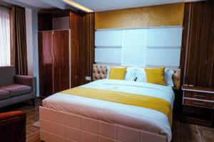 内罗毕Barre Hotel的一间卧室配有一张带黄色枕头的大床