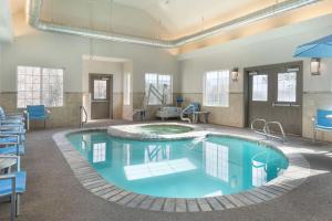 卡本代尔Comfort Inn & Suites Carbondale on the Roaring Fork的一个带蓝色椅子的房间的大型游泳池