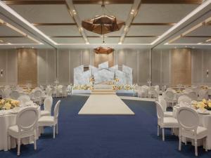 迪拜SO/ Uptown Dubai的宴会厅配有白色的桌椅和舞台