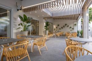 干尼亚Epavli Grace Hotel的一间空餐厅,配有桌椅和植物