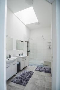 美因茨Gemütliche Ferienhaushälfte im Herzen Mainz的白色的浴室设有2个盥洗盆和1个浴缸。