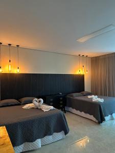 博阿维斯塔Villa'S Roraima - Pousada & Natureza的一间卧室配有两张带毛巾的床