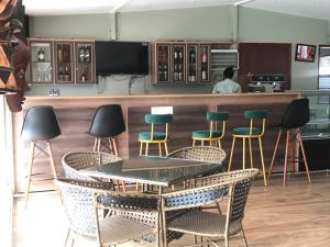 HoimaZebi Ecolodge的酒吧配有椅子、桌子和柜台