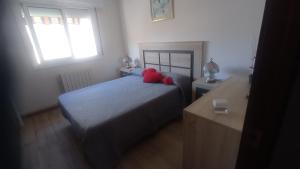 卡拉费尔Villa Delfín的一间卧室配有一张带两个红色枕头的床