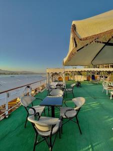 卢克索Luxor Aswan Victoria Nile Cruise every Saturday from Luxor 4 nights & every Wednesday from Aswan 3 nights的船上甲板上的一组桌椅