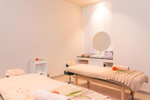 MokaRoyal Green Wellness Resort的一间医院间,配有两张床和镜子