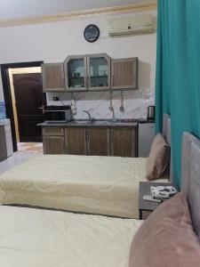 安曼Yaso Roof & Apartments的带两张床的房间和厨房