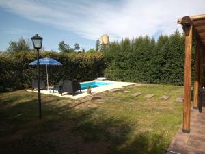 圣拉斐尔Casa ROMA的庭院内一个带椅子和遮阳伞的游泳池