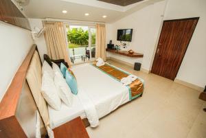 马哈巴利普拉姆Shelter Beach Resort的一间卧室配有一张大床和电视