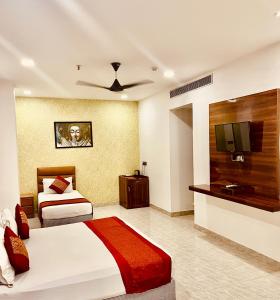 新德里Amora Rooms Dwarka的酒店客房设有两张床和一台平面电视。