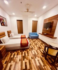 新德里Amora Rooms Dwarka的一间卧室配有一张床、一台电视和一张桌子