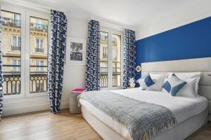 巴黎香榭丽舍歌剧院酒店的卧室配有蓝色和白色的窗帘和床
