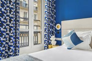巴黎香榭丽舍歌剧院酒店的蓝色和白色的卧室设有床和窗户