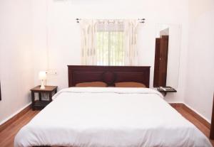 Moira4BHK Private Pool villa in North Goa and Kayaking nearby!!的白色的卧室设有一张大床和一个窗户