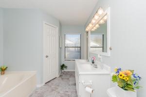 圣安东尼奥Superb House By Seaworld, Private Pool & Gameroom的白色的浴室设有两个盥洗盆、一个浴缸和镜子