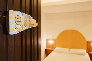 南圣弗朗西斯科Babitonga Hostel - 100m da Prainha的卧室配有一张床,墙上有标志