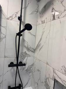 曼彻斯特Newly Renovated 3- Bed house in Prestwich的浴室铺有白色大理石瓷砖,设有淋浴。