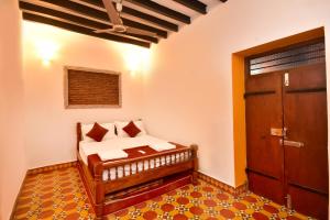 蓬蒂切里Villa D Jems -A Heritage Home stay的一间卧室配有一张带木门的床