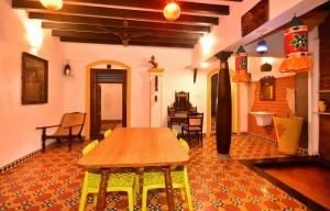 蓬蒂切里Villa D Jems -A Heritage Home stay的一间客房内配有木桌的房间