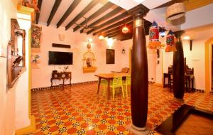 蓬蒂切里Villa D Jems -A Heritage Home stay的客厅配有桌子和墙上的电视