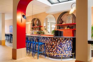 格罗宁根格罗宁根城市酒店的一间设有蓝色凳子的餐厅内的酒吧