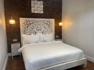 瓜隆岛Golden Beach Resort的卧室配有白色的床和砖墙