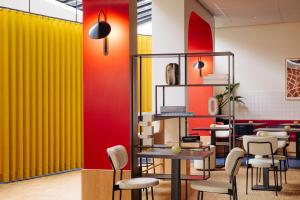 格罗宁根格罗宁根城市酒店的餐厅拥有黄色和红色的墙壁和椅子