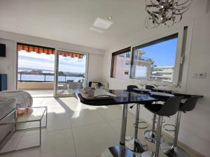 戛纳Cannes Vue mer T2 61m²+ parking的客厅配有桌子和一些窗户