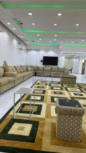 海米斯穆谢特برج موجان السكني التجاري的带沙发、桌子和屏幕的房间