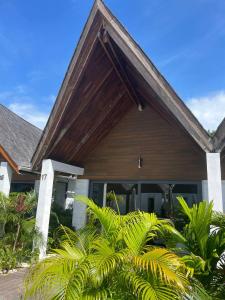 瓜隆岛Golden Beach Resort的一座木屋顶的房子,一些植物
