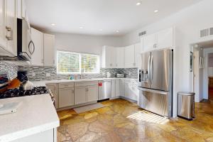 棕榈泉The Brentwood Permit# 3911的厨房配有白色橱柜和不锈钢冰箱