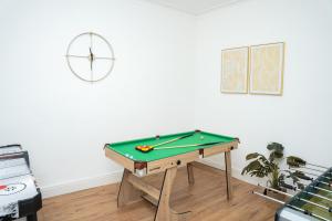 霍斯福斯Large Ideal Accommodation for Groups & Contractors的一间设有台球桌和墙上时钟的房间