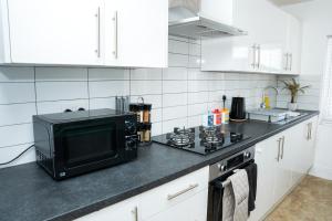 霍斯福斯Large Ideal Accommodation for Groups & Contractors的厨房配有黑色微波炉和炉灶。
