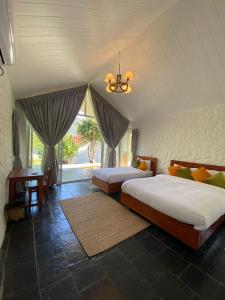 KusmaThe Cliff Resort Pokhara Kushma的一间卧室设有两张床和窗户。