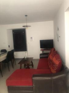 阿罗Gîtes chez Sylvie的客厅配有红色的沙发和桌子