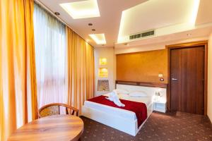 MedgidiaHotel Luxor的酒店客房配有一张床铺和一张桌子。