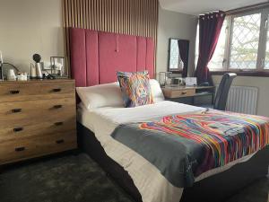 葛特纳格林猎人小屋酒店的一间卧室配有一张带梳妆台和书桌的床。