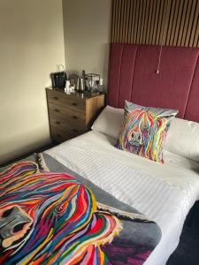 葛特纳格林猎人小屋酒店的一间卧室配有一张带枕头和梳妆台的床