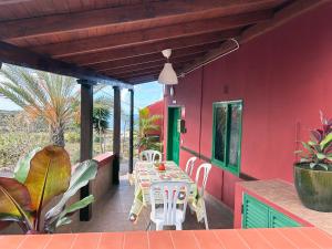 伊科德洛斯维诺斯Finca la Gaviota - Terazza的红色的房子,甲板上配有桌椅