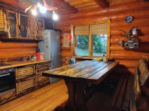 亚列姆切Дерев'яний котедж "Казка"的小屋内的厨房配有木桌