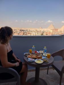 开罗Pyramids Orion inn的坐在桌子上吃喝的女人