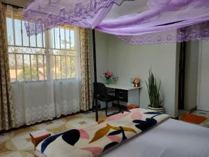 阿鲁沙Keeney House at St. Gabriel's的一间卧室配有一张紫色天蓬床